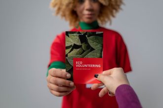 Mãos trocam um folheto sobre voluntariado e conscientização ambiental.